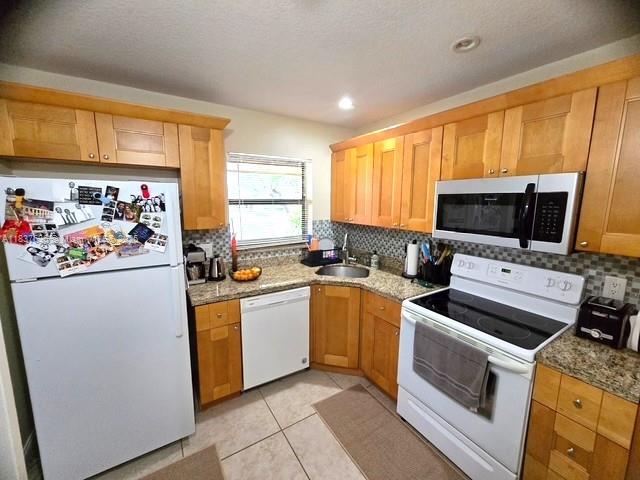 3817 Cocoplum Cir Unit 3585, Coconut Creek, FL 33063 - kitchen featuring white appliances, tasteful backsplash, stone counters, and recessed lighting