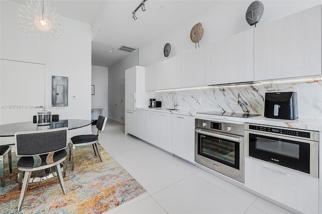 501 NE 31st St Unit 4007, Miami, FL 33137 - kitchen featuring stainless steel oven, light tile patterned floors, tasteful backsplash, and light countertops