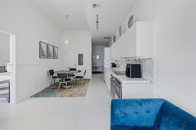 501 NE 31st St Unit 4007, Miami, FL 33137 - kitchen featuring electric panel, light countertops, light tile patterned floors, decorative backsplash, and rail lighting
