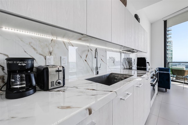 501 NE 31st St Unit 4007, Miami, FL 33137 - kitchen with modern cabinets, expansive windows, light stone countertops, and light tile patterned floors