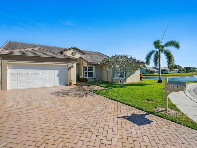 4024 Summer Chase Ct, Lake Worth, FL 33467 - ranch-style home featuring decorative driveway, a front yard, an attached garage, a water view, and stucco siding