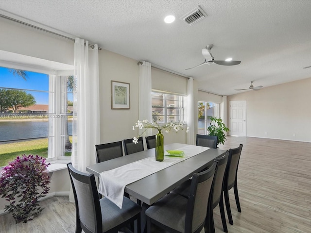 4024 Summer Chase Ct, Lake Worth, FL 33467 - dining area featuring light wood finished floors, a water view, a textured ceiling, a ceiling fan, and recessed lighting