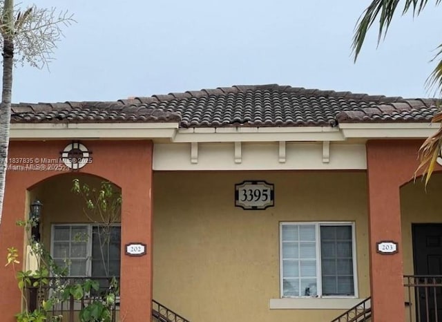 3395 NE 9th St Unit 104, Homestead, FL 33033 - view of exterior entry featuring a tile roof and stucco siding