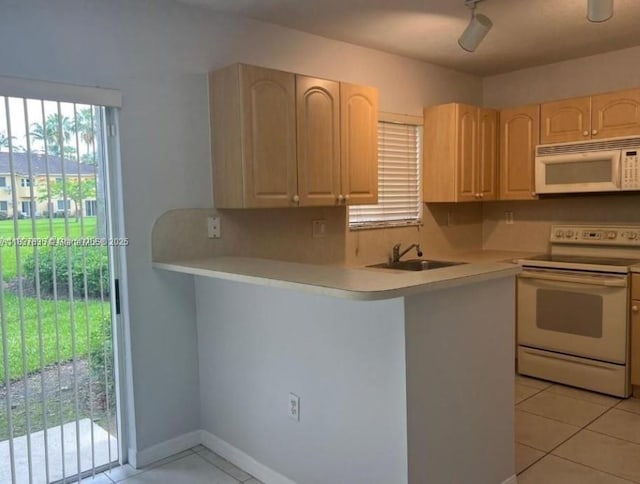3395 NE 9th St Unit 104, Homestead, FL 33033 - kitchen with white appliances, light brown cabinetry, light tile patterned floors, light countertops, and a peninsula