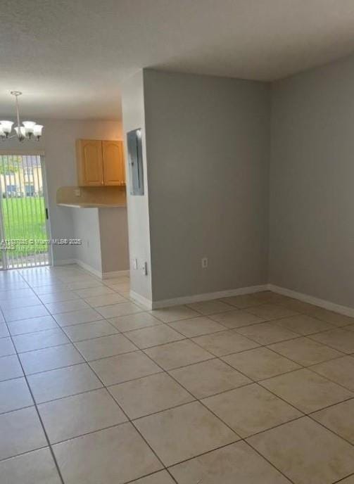 3395 NE 9th St Unit 104, Homestead, FL 33033 - spare room with light tile patterned floors, a chandelier, and electric panel