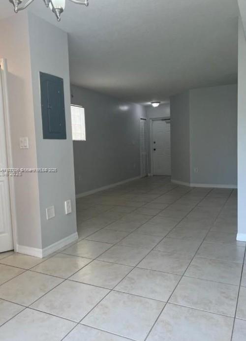3395 NE 9th St Unit 104, Homestead, FL 33033 - spare room with electric panel, light tile patterned floors, and a chandelier