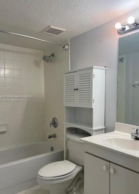 3395 NE 9th St Unit 104, Homestead, FL 33033 - bathroom featuring vanity, shower / washtub combination, a textured ceiling, and tile patterned floors