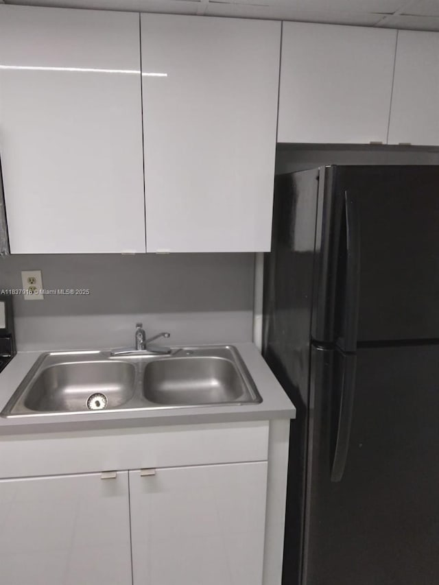 1305 W 46th St Unit 230, Hialeah, FL 33012 - kitchen featuring freestanding refrigerator, white cabinets, and light countertops