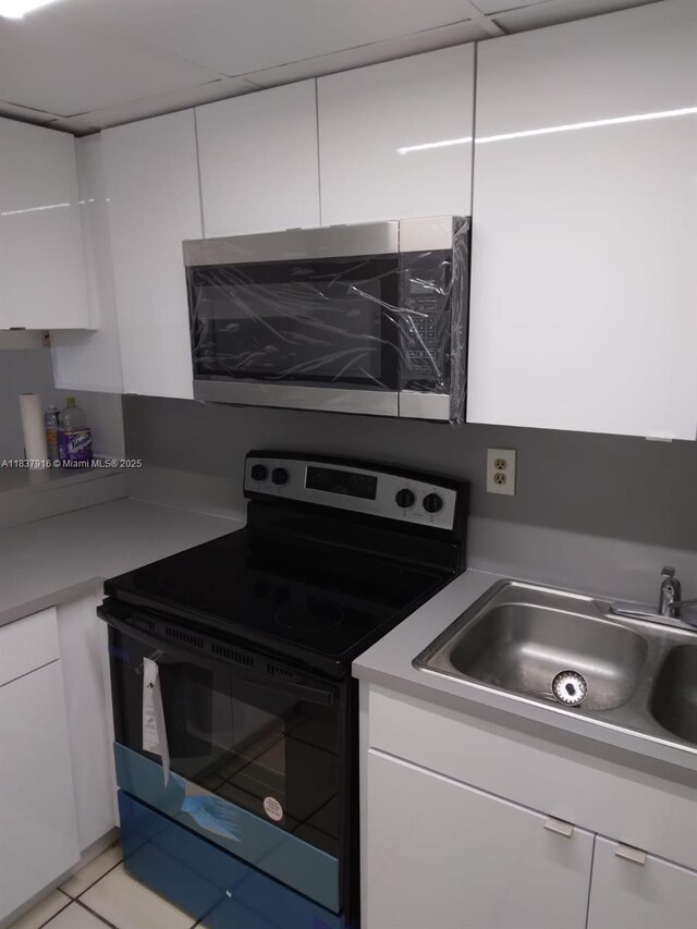 1305 W 46th St Unit 230, Hialeah, FL 33012 - kitchen with electric range, white cabinetry, and light countertops
