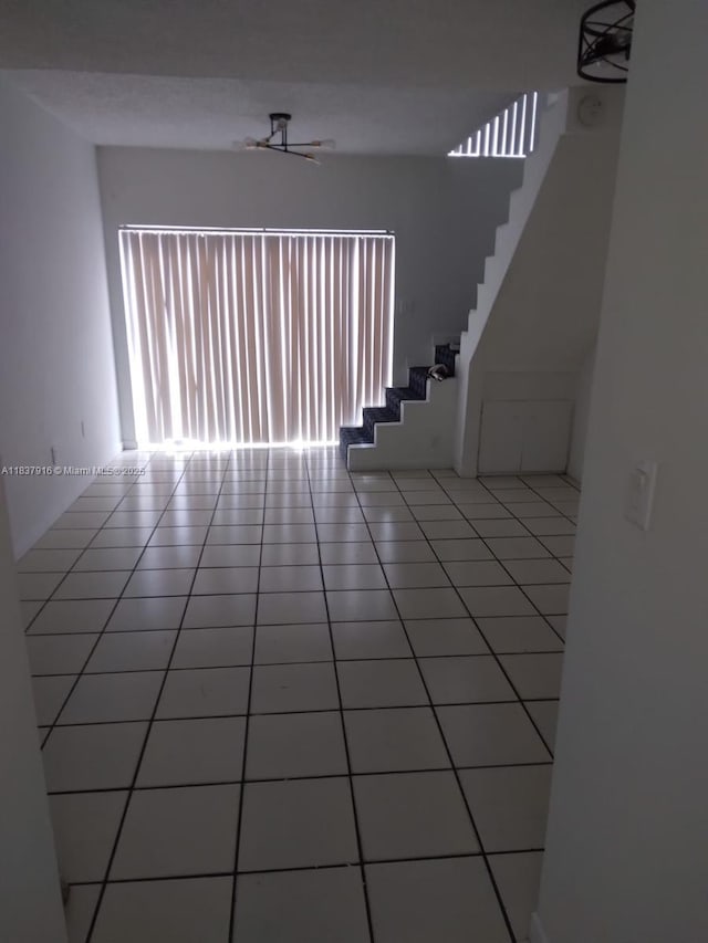 1305 W 46th St Unit 230, Hialeah, FL 33012 - unfurnished living room with healthy amount of natural light, stairway, and light tile patterned flooring