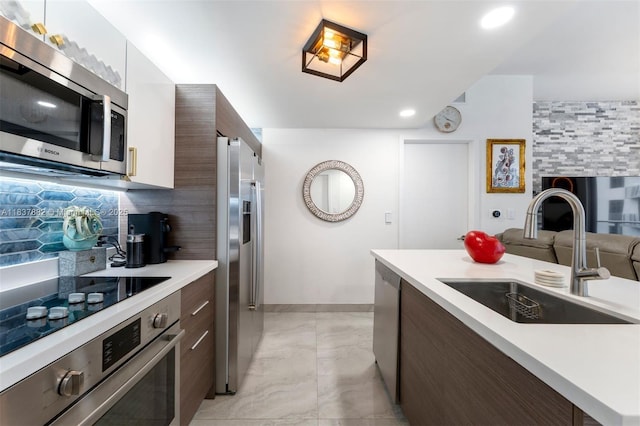 1010 SW 2nd Ave Unit Lph04, Miami, FL 33130 - kitchen featuring appliances with stainless steel finishes, modern cabinets, light countertops, dark brown cabinets, and decorative backsplash
