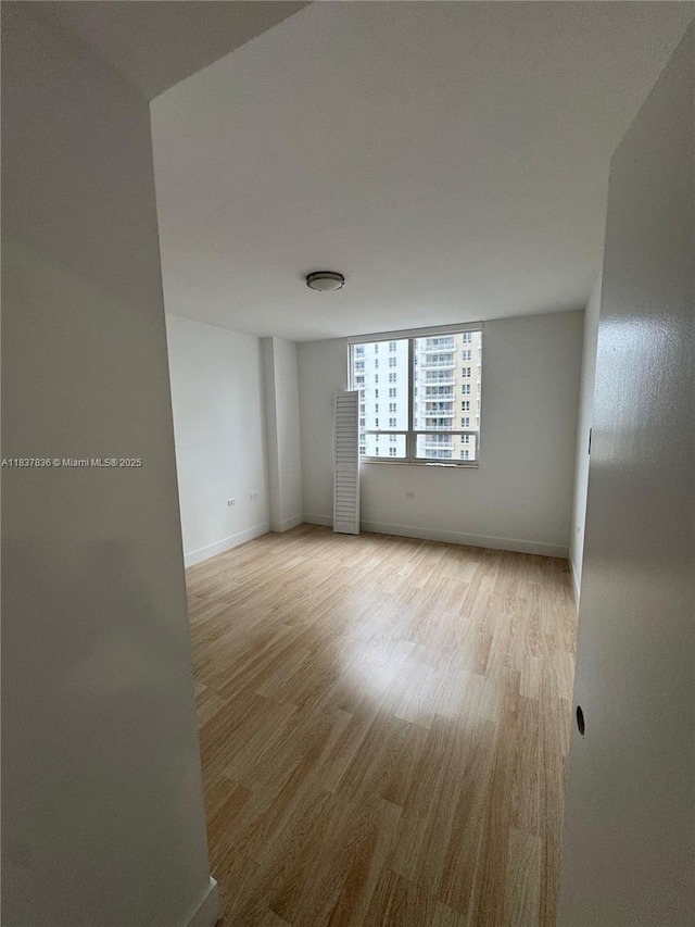 801 Brickell Key Blvd Unit 1005, Miami, FL 33131 - spare room with light wood-style flooring and baseboards