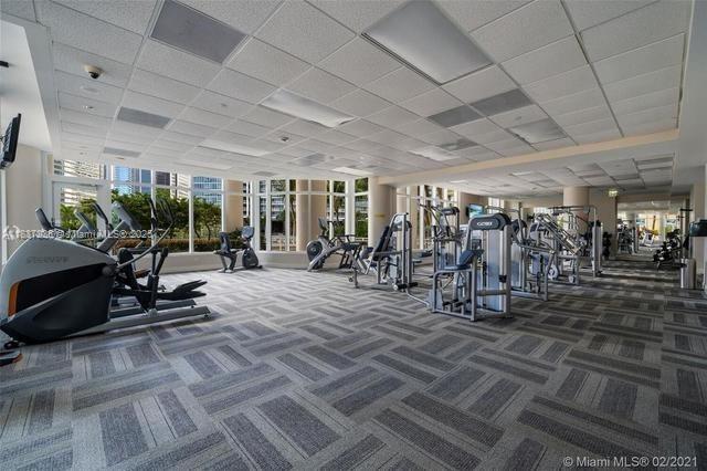 801 Brickell Key Blvd Unit 1005, Miami, FL 33131 - exercise room featuring carpet flooring, healthy amount of natural light, and a drop ceiling