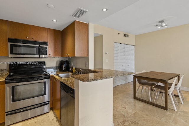770 Claughton Island Dr Unit Ph21, Miami, FL 33131 - kitchen featuring stainless steel appliances, a peninsula, brown cabinetry, dark stone countertops, and recessed lighting