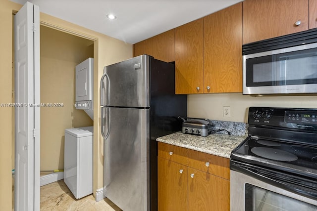 770 Claughton Island Dr Unit Ph21, Miami, FL 33131 - kitchen with stacked washer and clothes dryer, stainless steel appliances, light stone counters, brown cabinetry, and recessed lighting