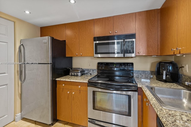 770 Claughton Island Dr Unit Ph21, Miami, FL 33131 - kitchen featuring stainless steel appliances, brown cabinets, light stone countertops, and recessed lighting