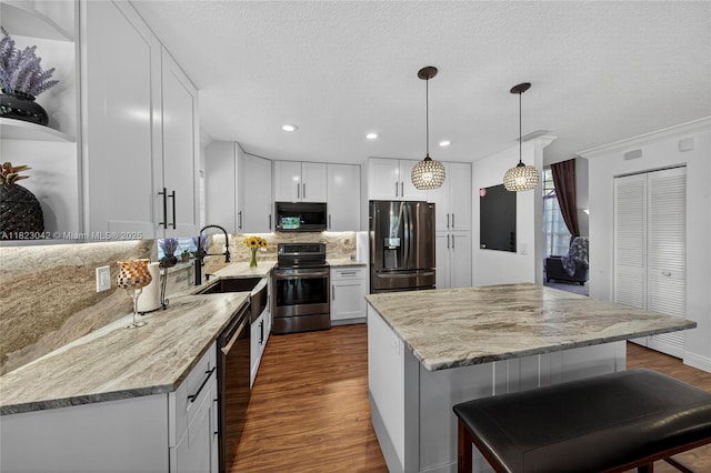 18205 NW 21st St, Pembroke Pines, FL 33029 - kitchen with stainless steel appliances, dark wood finished floors, decorative backsplash, light stone counters, and a center island