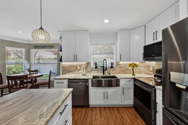 18205 NW 21st St, Pembroke Pines, FL 33029 - kitchen featuring stainless steel appliances, a textured ceiling, white cabinets, decorative backsplash, and wood finished floors