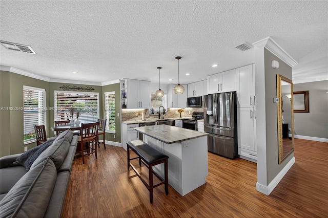 18205 NW 21st St, Pembroke Pines, FL 33029 - kitchen with stainless steel appliances, open floor plan, crown molding, a breakfast bar, and dark wood-style flooring