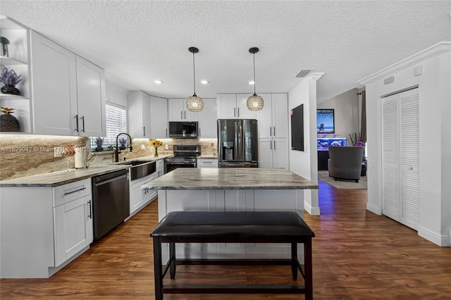 18205 NW 21st St, Pembroke Pines, FL 33029 - kitchen featuring appliances with stainless steel finishes, open shelves, dark wood finished floors, white cabinetry, and a textured ceiling