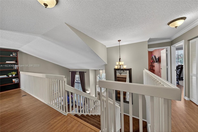 18205 NW 21st St, Pembroke Pines, FL 33029 - hallway featuring an upstairs landing, wood finished floors, a chandelier, ornamental molding, and a textured ceiling