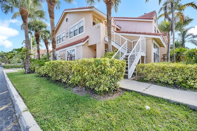 15560 SW 104th Ter Unit 611, Miami, FL 33196 - view of side of home with stairway, stucco siding, a yard, and a tiled roof