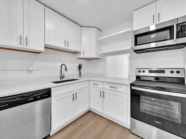 6000 NW 64th Ave Unit 303, Tamarac, FL 33319 - kitchen featuring appliances with stainless steel finishes, open shelves, light countertops, and white cabinetry