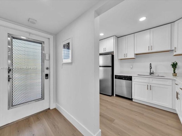 6000 NW 64th Ave Unit 303, Tamarac, FL 33319 - kitchen with appliances with stainless steel finishes, light wood finished floors, light countertops, white cabinetry, and recessed lighting