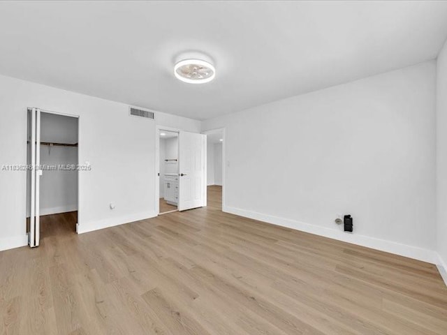 6000 NW 64th Ave Unit 303, Tamarac, FL 33319 - unfurnished bedroom with a spacious closet, light wood finished floors, and ensuite bathroom