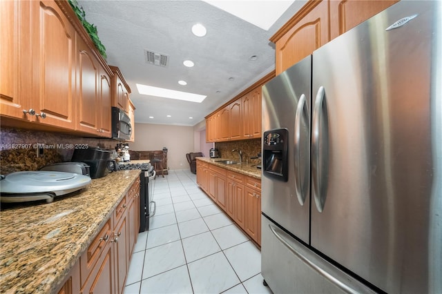 3631 SW 127th Ave, Miami, FL 33175 - kitchen with stainless steel appliances, a skylight, tasteful backsplash, light tile patterned flooring, and recessed lighting