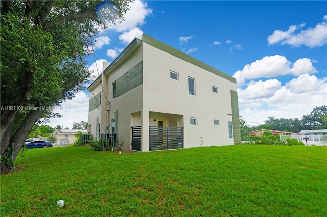 11128NW 17th Ave Unit 1-2, Miami, FL 33167 - rear view of house featuring stucco siding and a lawn