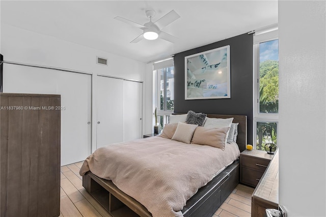 720 NE 62nd St Unit 301, Miami, FL 33138 - bedroom featuring two closets, multiple windows, light wood-style floors, and a ceiling fan