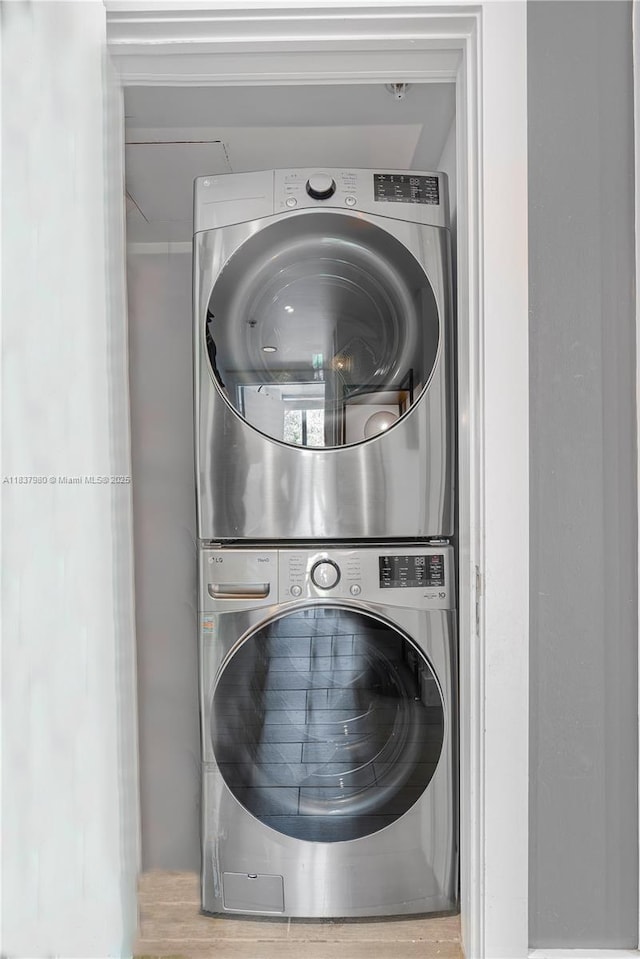 720 NE 62nd St Unit 301, Miami, FL 33138 - laundry room with estacked washer and dryer and wood finished floors