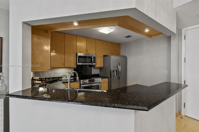 801 Brickell Key Blvd Unit 2006, Miami, FL 33131 - kitchen with appliances with stainless steel finishes, a peninsula, dark stone countertops, brown cabinets, and light tile patterned floors
