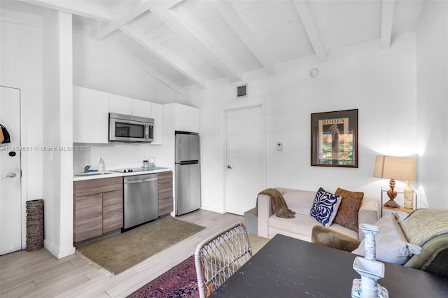 1450 Meridian Ave Unit 202, Miami Beach, FL 33139 - kitchen featuring stainless steel appliances, light wood-style floors, open floor plan, and light countertops