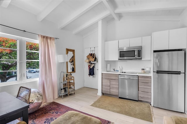 1450 Meridian Ave Unit 202, Miami Beach, FL 33139 - kitchen with appliances with stainless steel finishes, light wood finished floors, light countertops, white cabinets, and beam ceiling