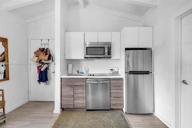 1450 Meridian Ave Unit 202, Miami Beach, FL 33139 - kitchen with stainless steel appliances, beam ceiling, light wood-style flooring, light countertops, and white cabinets