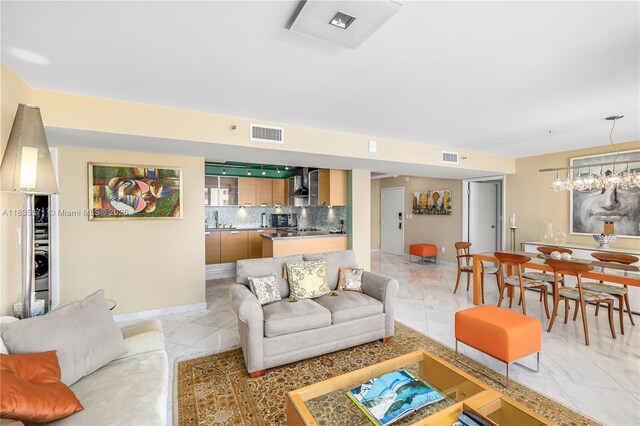 1623 Collins Ave Unit Ph1010, Miami Beach, FL 33139 - living area featuring light marble finish floors, washer / dryer, and a chandelier