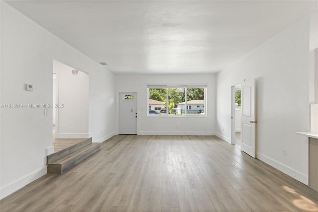775 NE 145th St, North Miami, FL 33161 - unfurnished living room with light wood-style flooring and baseboards