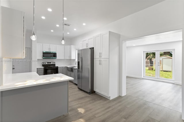 775 NE 145th St, North Miami, FL 33161 - kitchen with appliances with stainless steel finishes, recessed lighting, light countertops, light wood finished floors, and tasteful backsplash