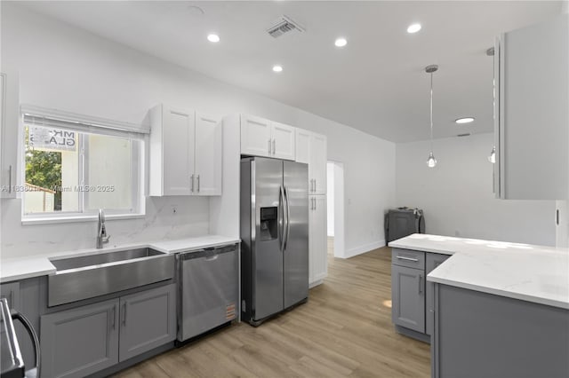 775 NE 145th St, North Miami, FL 33161 - kitchen with stainless steel appliances, gray cabinets, light wood-type flooring, recessed lighting, and decorative light fixtures