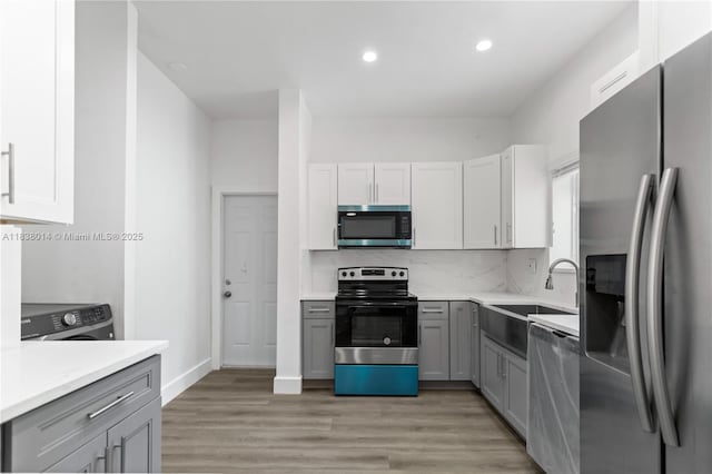 775 NE 145th St, North Miami, FL 33161 - kitchen featuring stainless steel appliances, recessed lighting, gray cabinets, light countertops, and light wood-type flooring