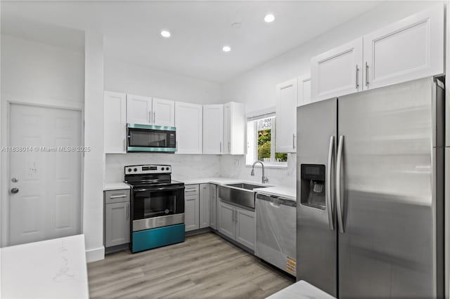 775 NE 145th St, North Miami, FL 33161 - kitchen with appliances with stainless steel finishes, recessed lighting, gray cabinets, decorative backsplash, and light wood-style flooring