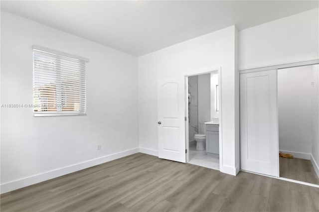 775 NE 145th St, North Miami, FL 33161 - unfurnished bedroom with wood finished floors, a closet, and connected bathroom