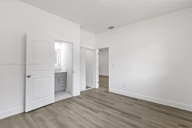 775 NE 145th St, North Miami, FL 33161 - unfurnished bedroom with wood finished floors and ensuite bathroom