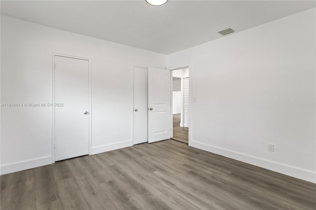 775 NE 145th St, North Miami, FL 33161 - unfurnished bedroom featuring wood finished floors and multiple closets