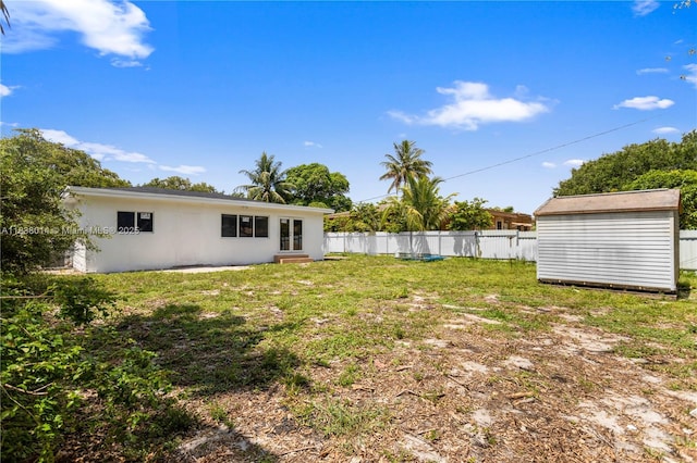 775 NE 145th St, North Miami, FL 33161 - view of yard with a storage unit, french doors, and entry steps