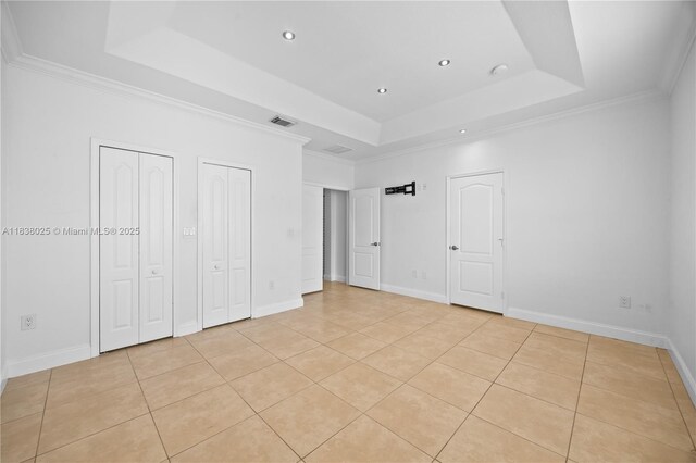 15057 SW 9th Ter, Miami, FL 33194 - unfurnished bedroom with a tray ceiling, two closets, light tile patterned flooring, recessed lighting, and ornamental molding