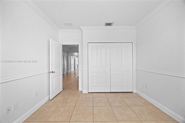 15057 SW 9th Ter, Miami, FL 33194 - unfurnished bedroom featuring ornamental molding, light tile patterned floors, and a closet