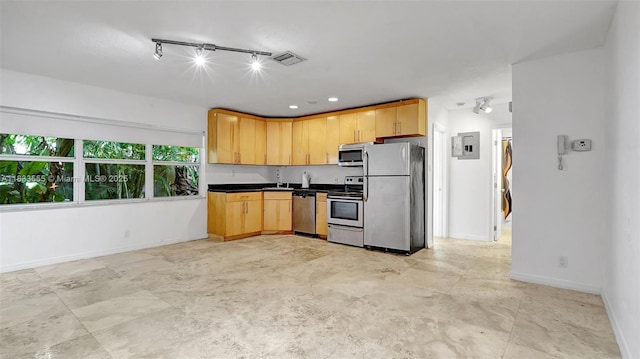 1348 Holly Heights Dr Unit 17, Fort Lauderdale, FL 33304 - kitchen featuring stainless steel appliances, dark countertops, light brown cabinets, rail lighting, and electric panel